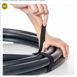 Image 4-13-26 at 427 PM - Speedtech International A person’s hands secure a bundle of thick black cables using a SPEEDWRAP® Wire Wrap hook-and-loop strap.