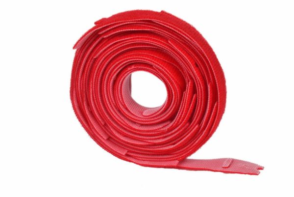 A coiled roll of red hook-and-loop fastener (Velcro) tape, with one end slightly unrolled, on a white background.