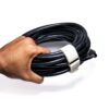 A hand holds a coiled black cable secured with a white SPEEDWRAP® High Temp Cinch Strap, against a white background.
