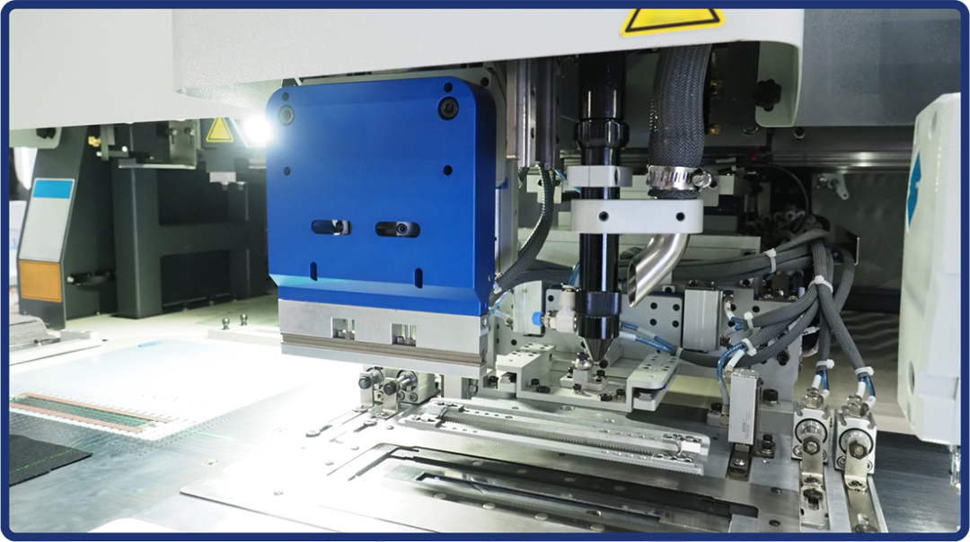 A close-up view of an automated machine assembling electronic components on a circuit board in a modern manufacturing facility, featuring metal parts, wires, and precise robotic mechanisms.