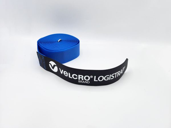 A rolled blue VELCRO® Brand LOGISTRAP® Pallet Strap with a black end piece featuring the brand logo, set against a plain white background.